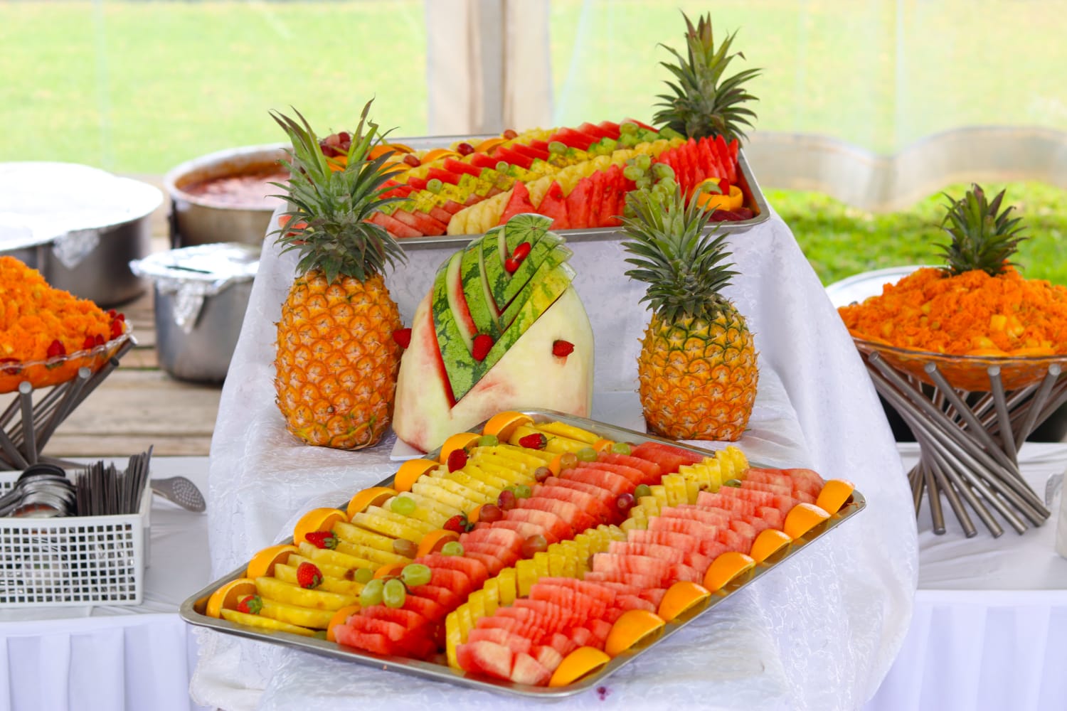 Pineapple and watermelon platters with a carved fruit centrepiece