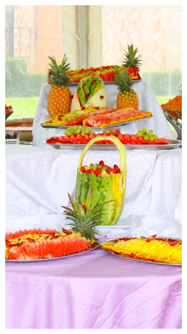 A tiered fruit buffet with a carved watermelon basket