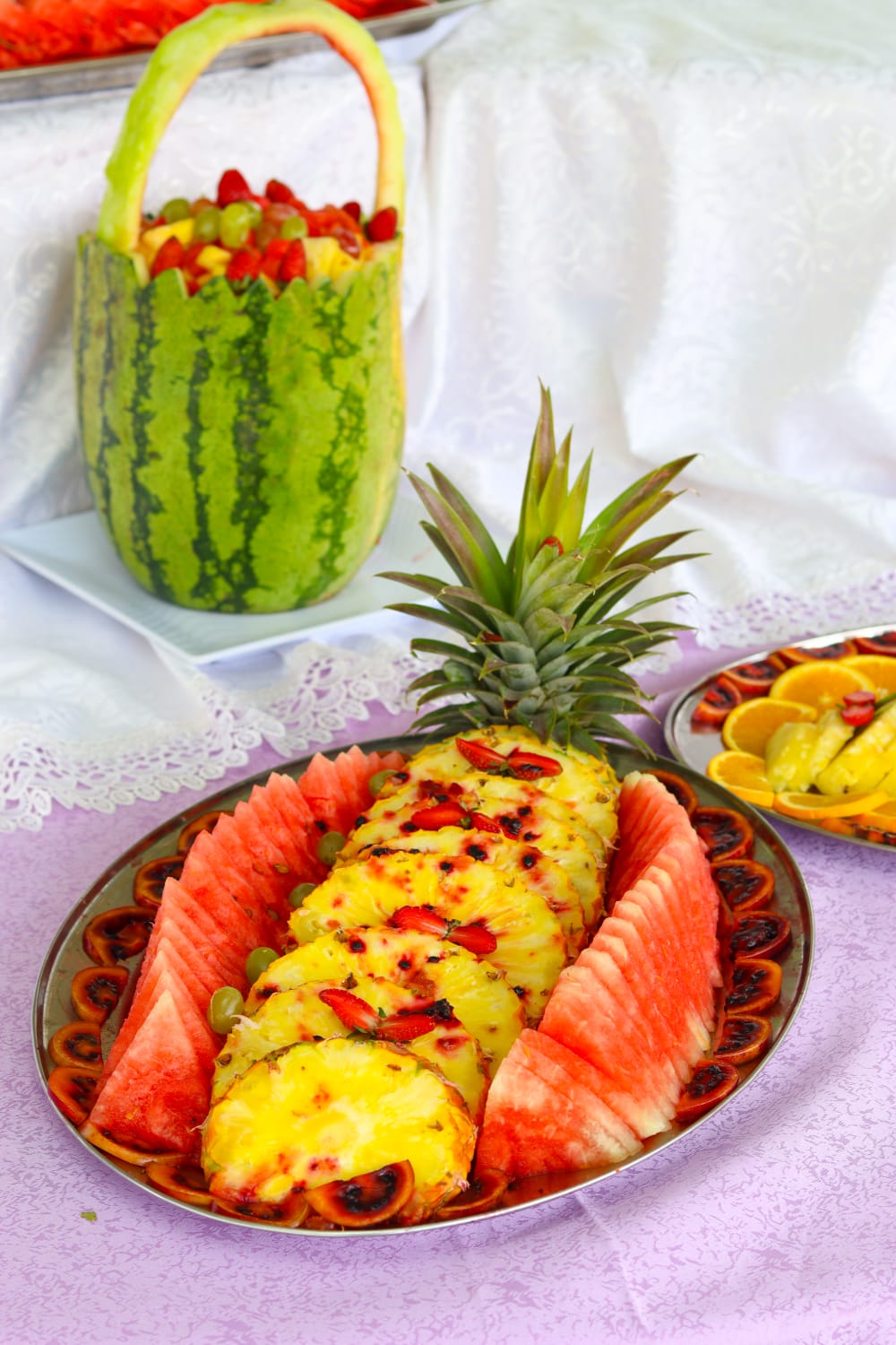 Pineapple and watermelon platter beside a fruit basket